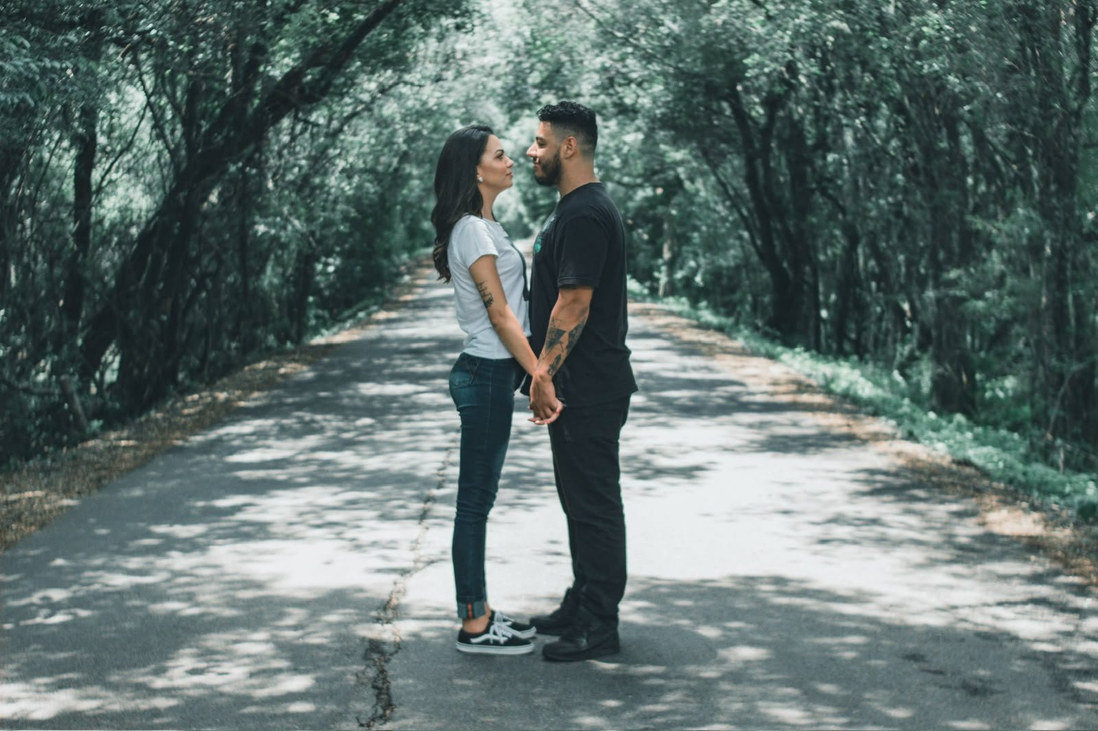 Cássia e Pablo de mãos dadas em uma estrada arborizada